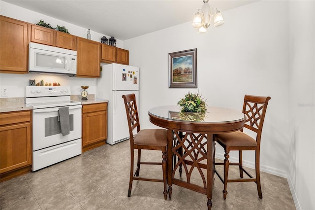 kitchen featuring hanging light fixtures, light tile patterned flooring, white appliances, and a chandelier