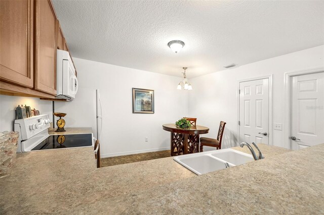 kitchen featuring hanging light fixtures, sink, a notable chandelier, a textured ceiling, and white appliances