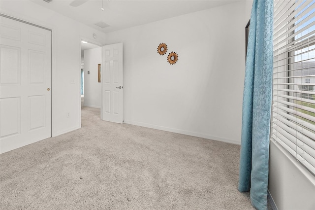 unfurnished bedroom featuring ceiling fan and light colored carpet