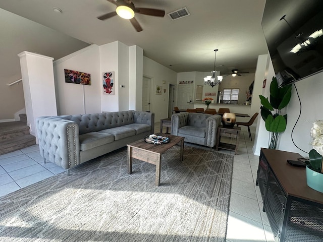 tiled living room with ceiling fan with notable chandelier