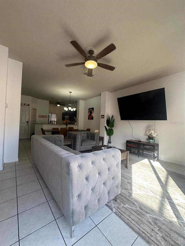 tiled living room featuring ceiling fan with notable chandelier and a textured ceiling