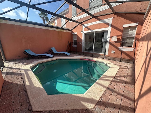 view of swimming pool with a patio and glass enclosure