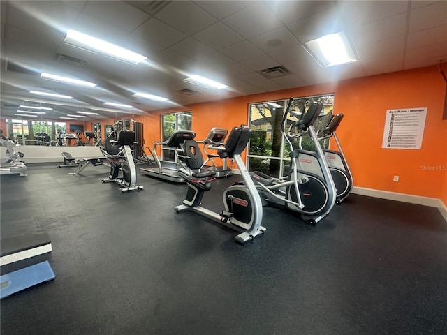 gym with a drop ceiling and plenty of natural light