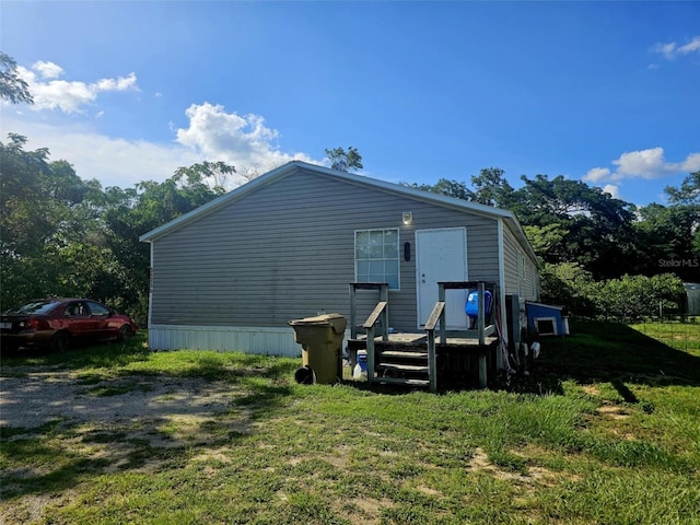 rear view of property featuring a lawn