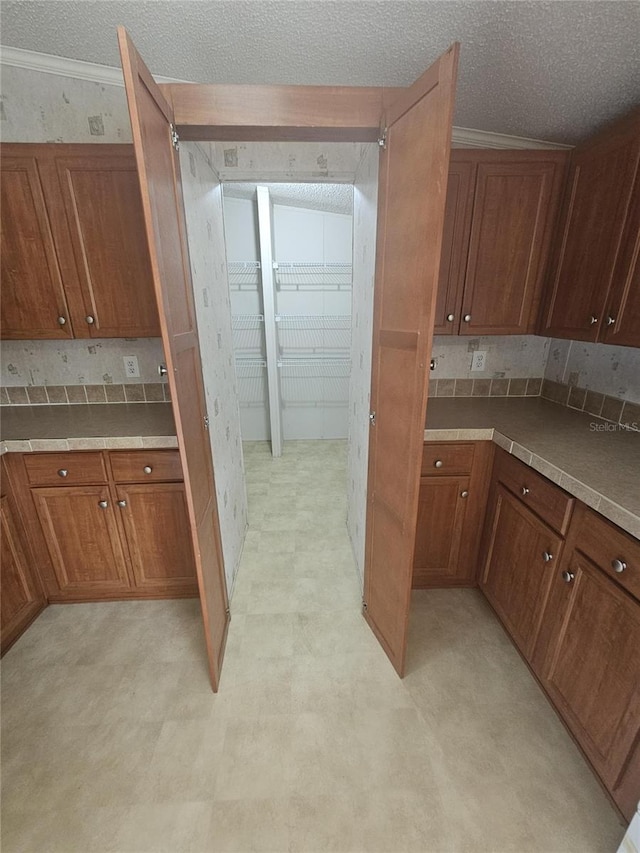 kitchen with a textured ceiling and ornamental molding