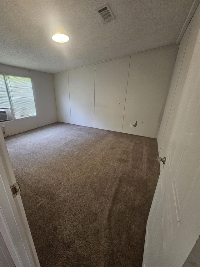 empty room with a textured ceiling and carpet