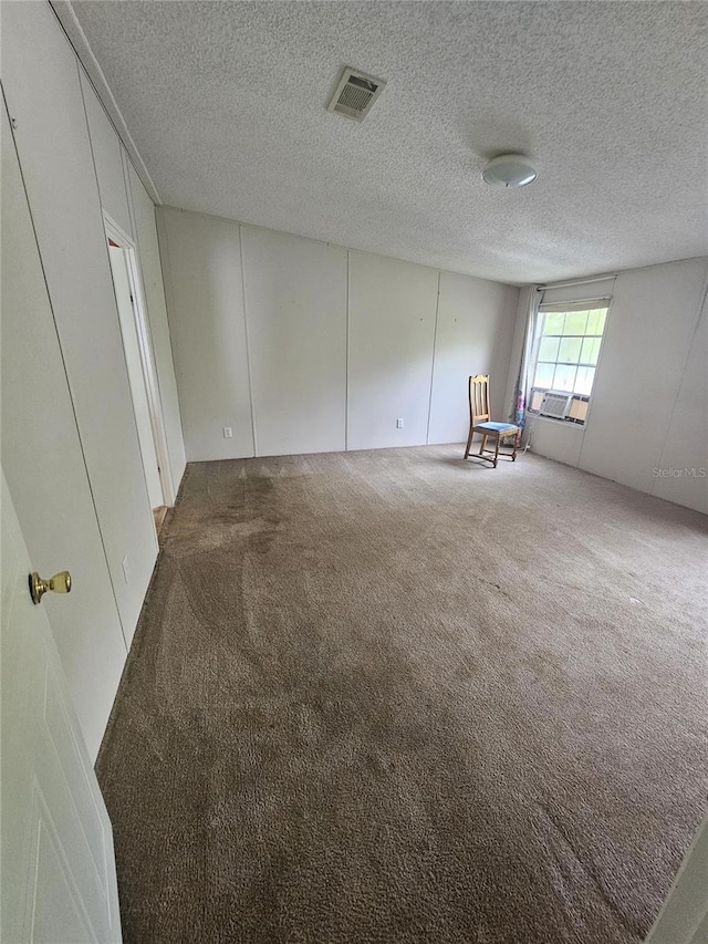 unfurnished room featuring carpet flooring and a textured ceiling