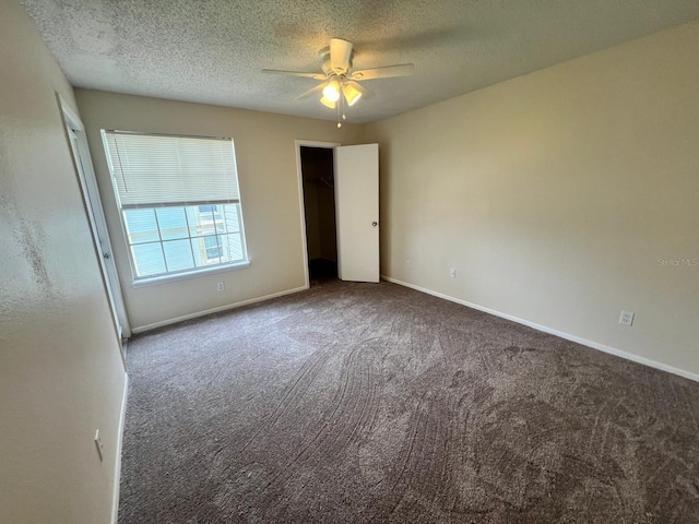 empty room featuring carpet floors, ceiling fan, baseboards, and a textured ceiling