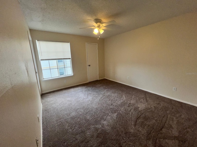 carpeted empty room with baseboards, ceiling fan, and a textured ceiling