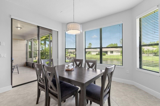 dining area with light tile patterned floors, a wealth of natural light, and baseboards