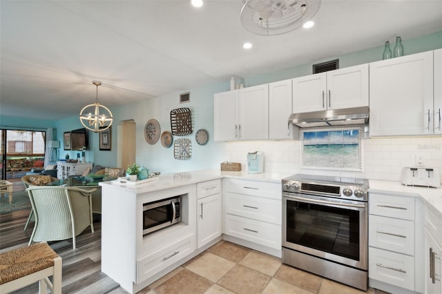 kitchen with backsplash, an inviting chandelier, appliances with stainless steel finishes, light hardwood / wood-style floors, and white cabinetry