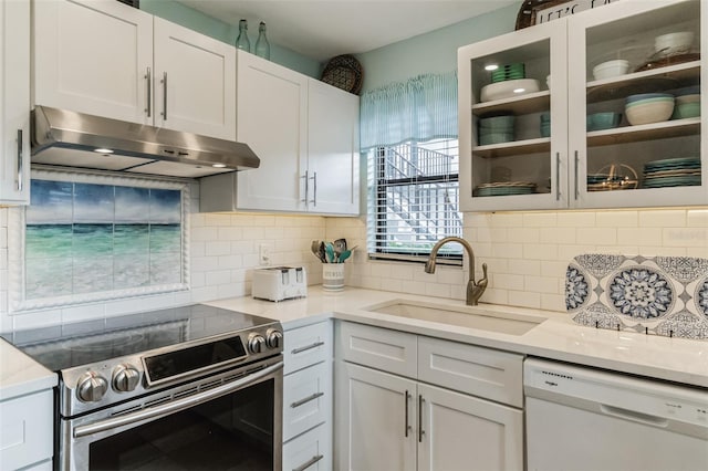 kitchen with tasteful backsplash, sink, white cabinets, white dishwasher, and stainless steel electric stove