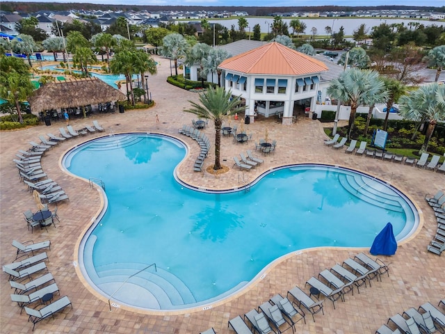 view of pool featuring a water view and a patio