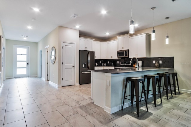 kitchen with backsplash, pendant lighting, black fridge with ice dispenser, white cabinetry, and kitchen peninsula