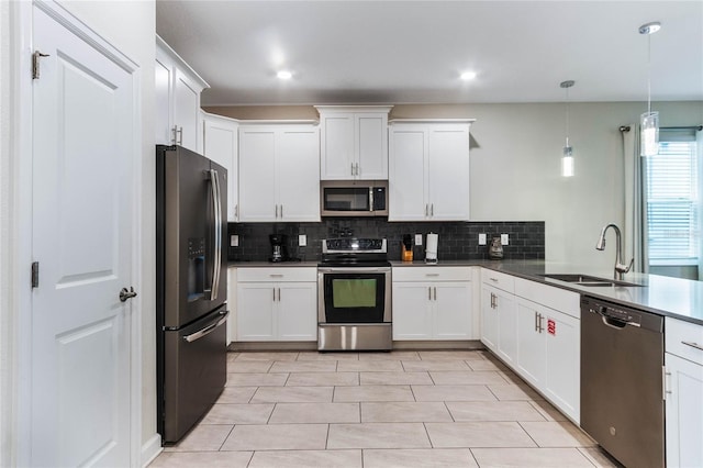 kitchen with light tile patterned flooring, sink, hanging light fixtures, tasteful backsplash, and stainless steel appliances