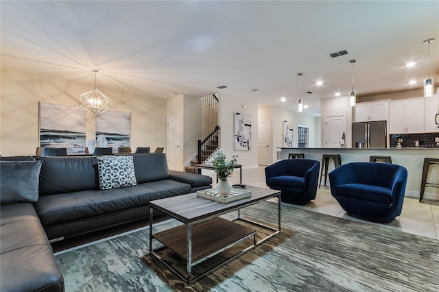 living room with light tile patterned flooring and an inviting chandelier