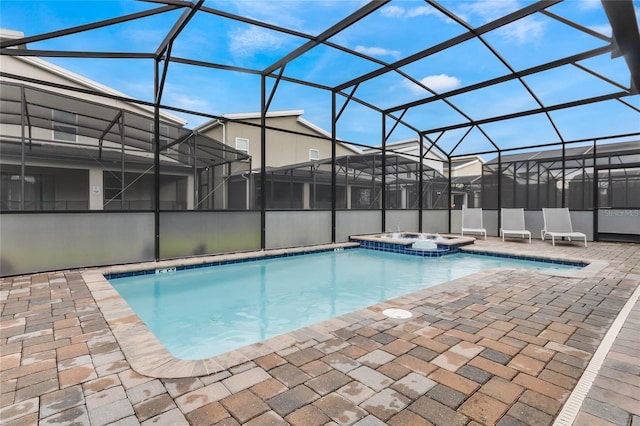 view of pool with glass enclosure, an in ground hot tub, and a patio