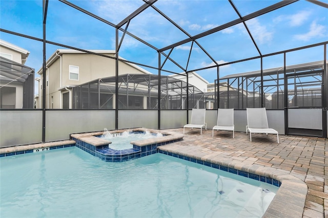 view of swimming pool featuring an in ground hot tub, glass enclosure, and a patio