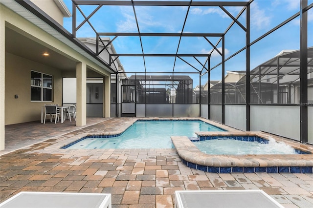 view of pool with an in ground hot tub, a patio area, and a lanai