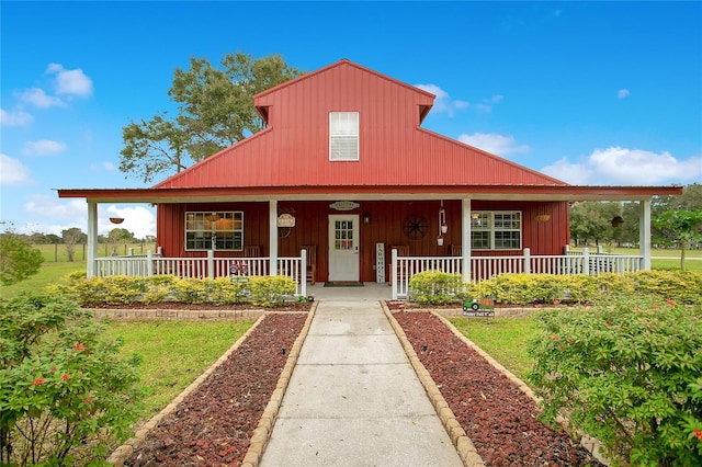 farmhouse-style home featuring a porch and a front yard