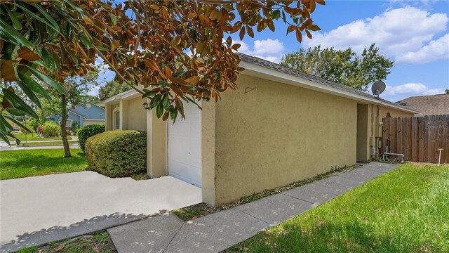 view of side of property with a lawn and a garage