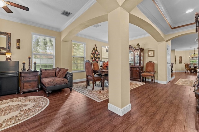 living area featuring ceiling fan, crown molding, and dark hardwood / wood-style floors