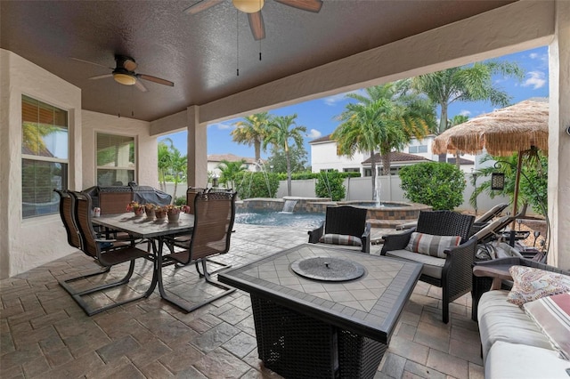 view of patio / terrace featuring ceiling fan, an outdoor living space with a fire pit, a fenced in pool, and pool water feature