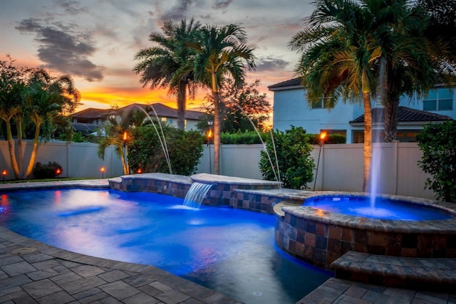 pool at dusk featuring pool water feature