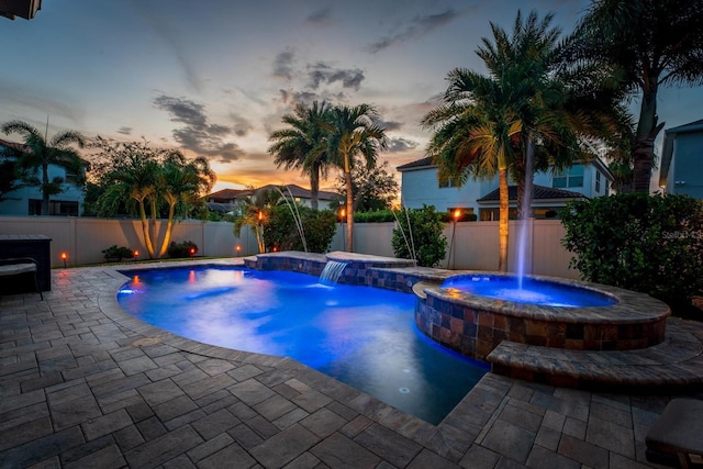 pool at dusk featuring a patio area and pool water feature