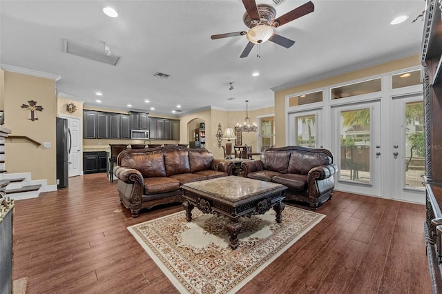 living room featuring ceiling fan with notable chandelier, hardwood / wood-style flooring, and crown molding