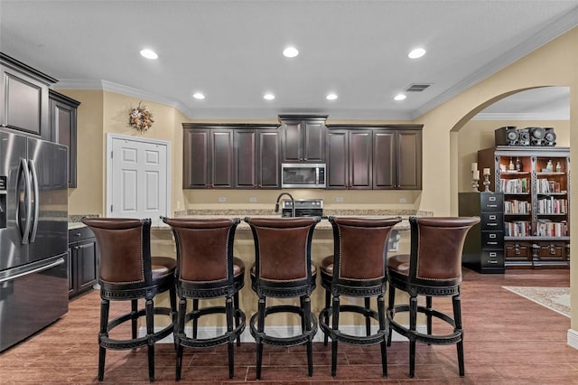 kitchen featuring visible vents, arched walkways, stainless steel appliances, light countertops, and light wood-type flooring