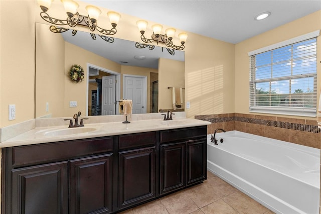 bathroom with dual vanity, a tub, and tile patterned floors