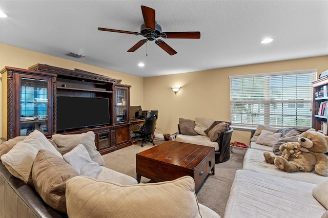 carpeted living area with a textured ceiling, a ceiling fan, visible vents, and recessed lighting