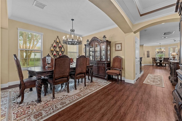 dining area with a chandelier, arched walkways, dark wood-style flooring, and visible vents