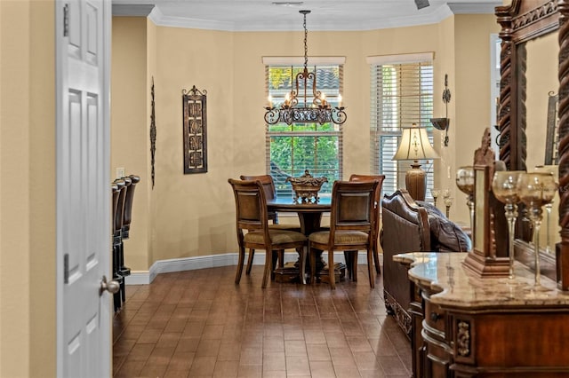 dining area with a notable chandelier, ornamental molding, and dark tile patterned floors