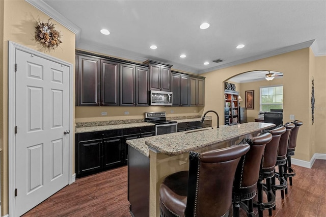 kitchen featuring ceiling fan, appliances with stainless steel finishes, ornamental molding, and dark hardwood / wood-style flooring