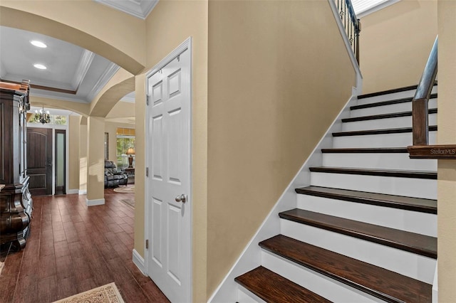 stairs with arched walkways, recessed lighting, wood finished floors, baseboards, and crown molding