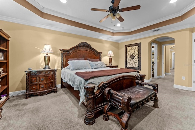 bedroom with ceiling fan, light carpet, a raised ceiling, and ornamental molding