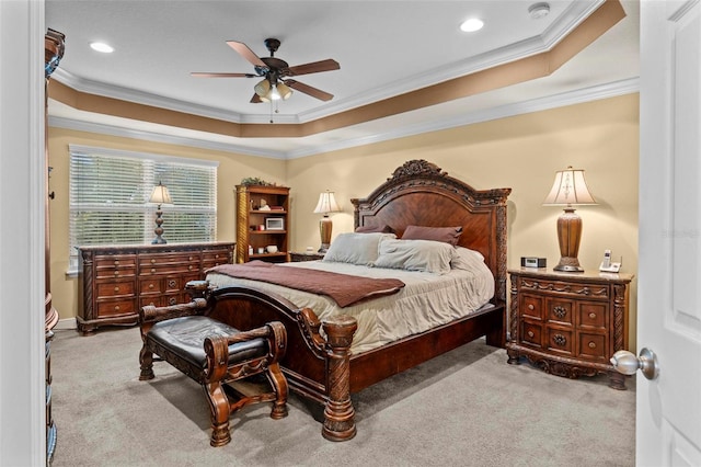 carpeted bedroom featuring a ceiling fan, a tray ceiling, crown molding, and recessed lighting