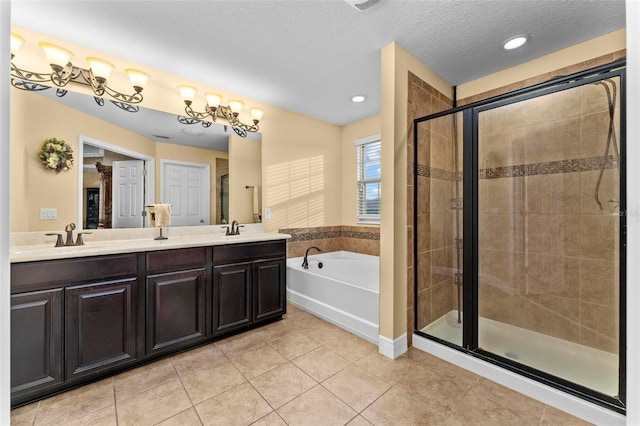 bathroom featuring independent shower and bath, double vanity, tile patterned floors, and a textured ceiling