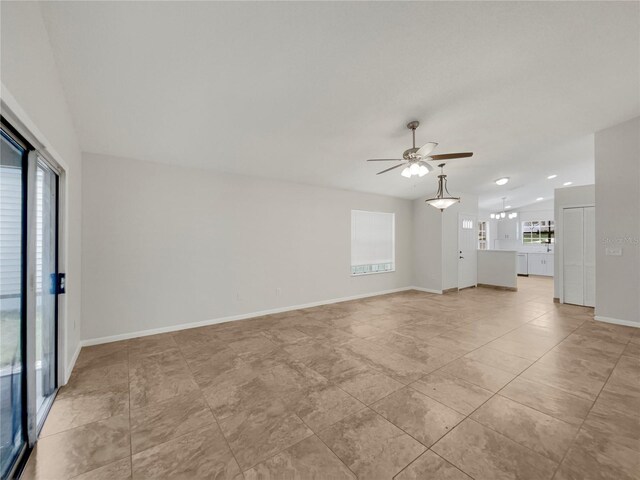 unfurnished living room featuring a wealth of natural light, light tile patterned flooring, and ceiling fan