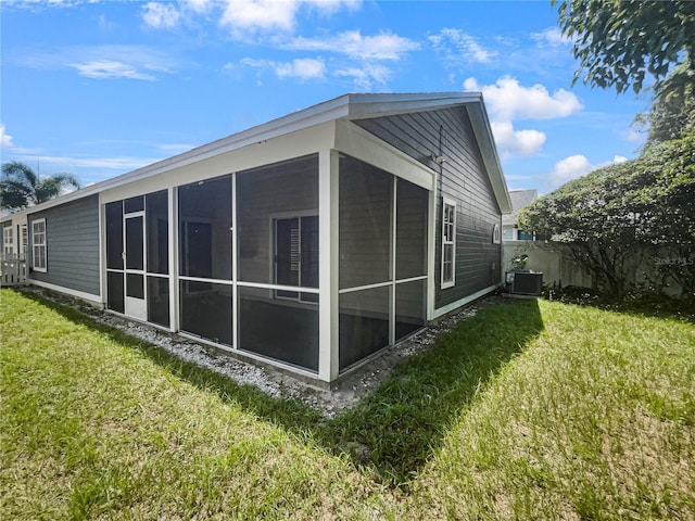 view of home's exterior featuring cooling unit, a lawn, and a sunroom