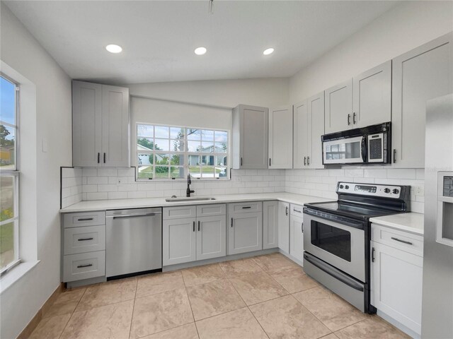 kitchen featuring backsplash, appliances with stainless steel finishes, and light tile patterned flooring