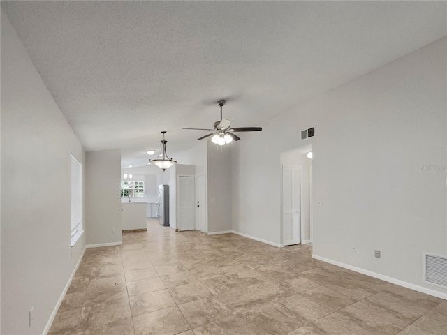 spare room featuring vaulted ceiling, a textured ceiling, and ceiling fan