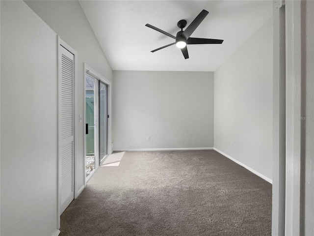 unfurnished room featuring ceiling fan, vaulted ceiling, a healthy amount of sunlight, and dark carpet