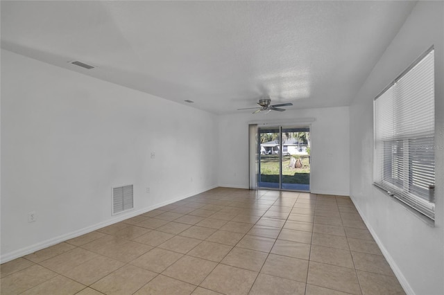 tiled spare room with ceiling fan