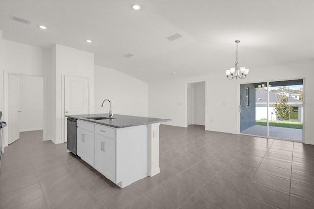 kitchen featuring dishwasher, dark stone counters, decorative light fixtures, white cabinets, and a kitchen island with sink