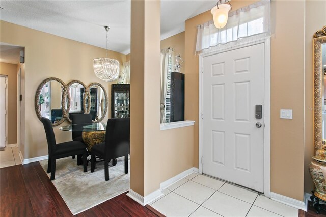 tiled foyer entrance with an inviting chandelier