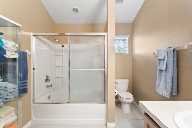 full bathroom with tile patterned flooring, toilet, shower / bath combination with glass door, and vanity