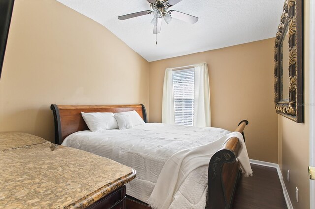 bedroom with ceiling fan, dark hardwood / wood-style floors, and lofted ceiling